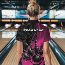Load image into Gallery viewer, Back view of a female model in a bowling lane wearing a black and pink polo shirt featuring gradient bowling ball pattern with flaming black bowling ball striking pins dynamic design.