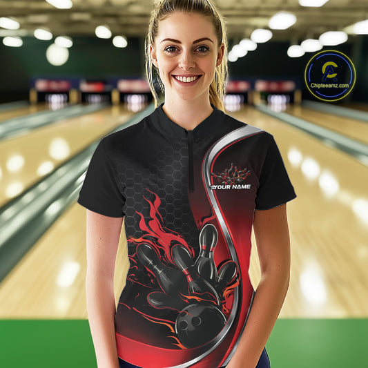 Female model front view in bowling alley wearing black and red quarter zip shirt with flaming bowling action artwork