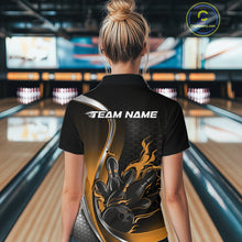 Load image into Gallery viewer, Female model back view at bowling lane wearing a black and yellow polo shirt with flaming bowling ball hitting pins in bold athletic motion artwork.