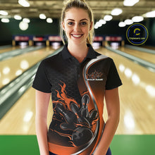 Load image into Gallery viewer, Female model front view in bowling lane wearing black and orange polo shirt with flaming bowling ball striking pins in dynamic sports scene.
