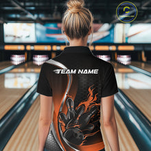 Load image into Gallery viewer, Female model back view at bowling venue wearing black and orange polo shirt showcasing flame bowling ball striking pins in bold motion artwork.
