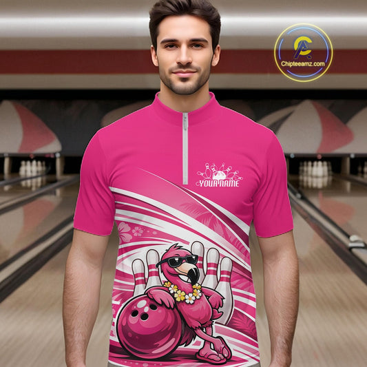 Male model wearing a pink bowling quarter-zip shirt at a bowling lane with a tropical flamingo in sunglasses beside a bowling ball.
