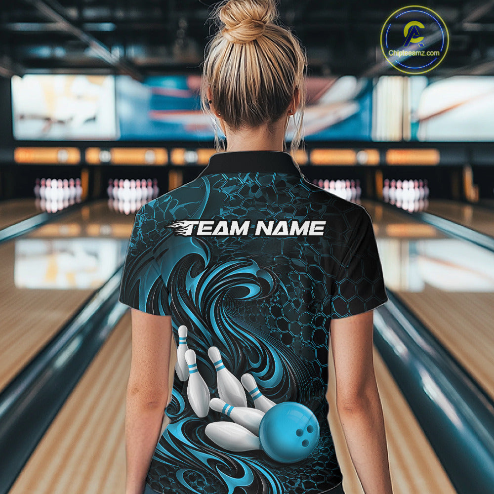 Back view of a female model wearing a black and blue bowling quarter-zip shirt in a bowling alley featuring a tribal flame bowling ball and pins graphic