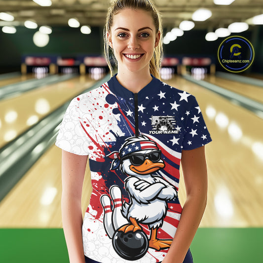 Female model in bowling lane wearing quarter-zip shirt featuring patriotic duck sunglasses beside bowling ball illustration