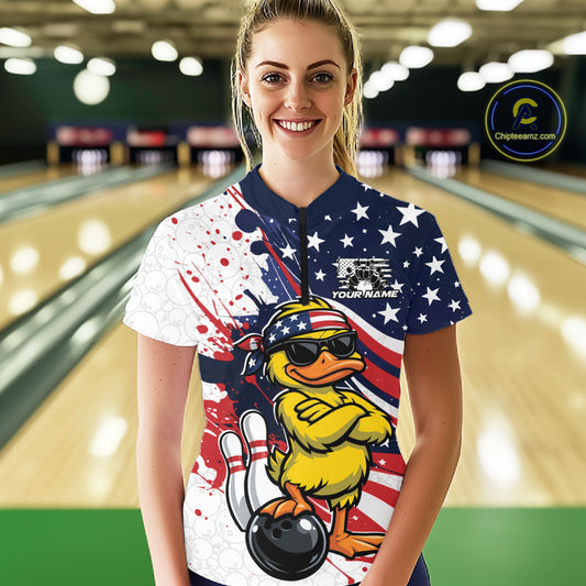 Female model in bowling lane wearing quarter-zip shirt with patriotic duck sunglasses bowling ball graphic