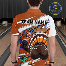 Load image into Gallery viewer, Back view of a male model wearing an orange custom bowling polo shirt featuring a funny graffiti style turkey holding a bowling ball, paint splatter details, and a custom name in a bowling alley.