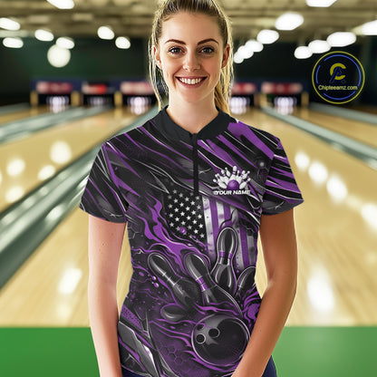 Female model in a bowling lane wearing a black and purple quarter zip shirt, front view featuring patriotic flames bowling ball striking pins with American flag inspired graphics