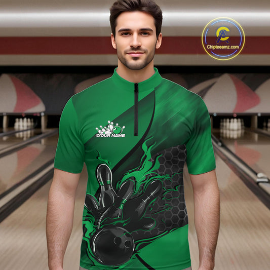 Male model at a bowling lane wearing a black and green bowling quarter-zip shirt with flame bowling strike artwork and hexagonal graphics.
