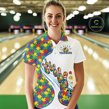 Load image into Gallery viewer, Female model in a bowling lane wearing a white polo shirt, front view highlighting autism-themed bowling strike illustration with puzzle-inspired design
