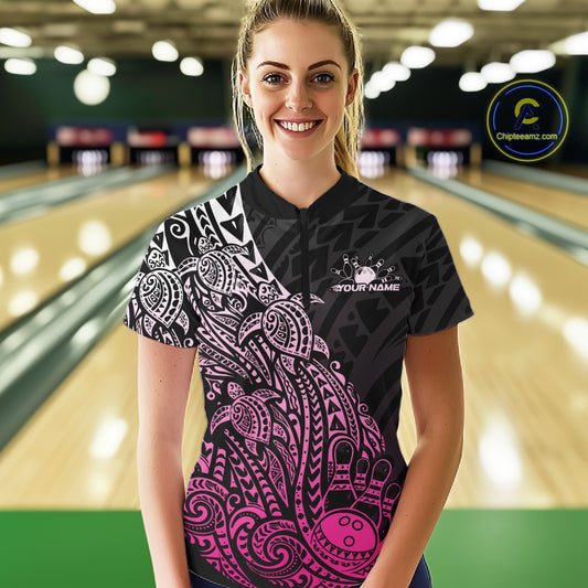 Female model wearing a black and pink bowling quarter-zip shirt at the bowling lane with Polynesian-style bowling artwork.