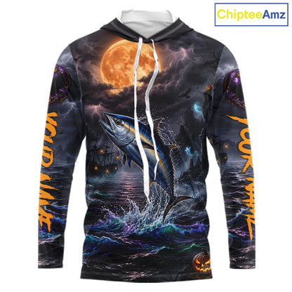 A long-sleeve hoodie with an all-over Halloween-themed graphic print featuring a jumping fish under a full moon, dark stormy sky, lightning, and orange text on the sleeves. The hoodie has a white drawstring and is shown on a plain white background with a ChipteeAmz logo in the top right corner.