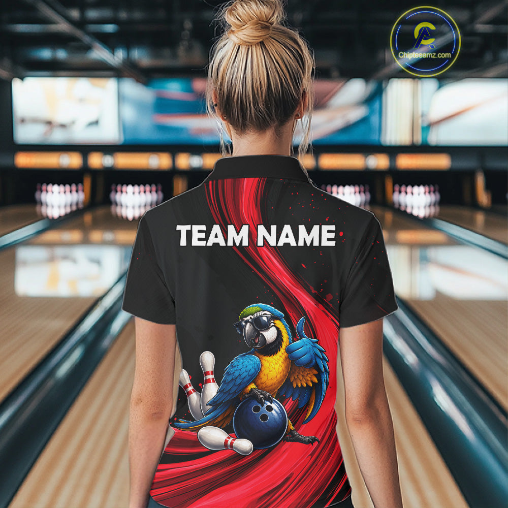 A woman viewed from behind wearing a black short-sleeve bowling-themed polo shirt with a large red graphic, a blue-and-yellow parrot, bowling pins, and a blue bowling ball on the back. The shirt also has white placeholder text reading TEAM NAME.