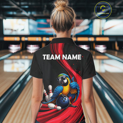 A woman viewed from behind wearing a black short-sleeve bowling-themed polo shirt with a large red graphic, a blue-and-yellow parrot, bowling pins, and a blue bowling ball on the back. The shirt also has white placeholder text reading TEAM NAME.