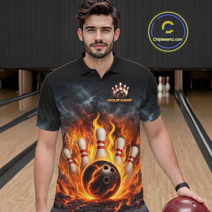 A man wearing a black short-sleeve polo shirt with a fiery bowling graphic print, standing in a bowling alley. The shirt features a dramatic design of bowling pins, a bowling ball, and orange flames.