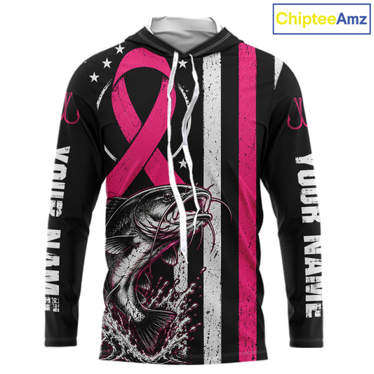 A black long-sleeve hoodie with a pink and white distressed design featuring a large pink ribbon, a fish graphic, white stars, and vertical text on the sleeves. The hood is open, showing a gray interior lining.