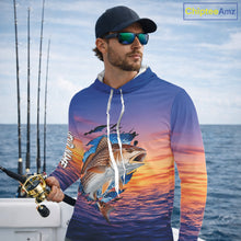 Load image into Gallery viewer, Angler wearing Redfish Fishing Sunset custom long sleeve hooded redfish offshore fishing shirt on the boat at sunset