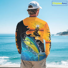 Load image into Gallery viewer, Person wearing a mahi mahi long sleeve fishing shirt with a fishing design by the ocean.