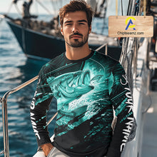 Load image into Gallery viewer, Man wearing a long sleeve fishing shirt with a teal bass fish design on a boat