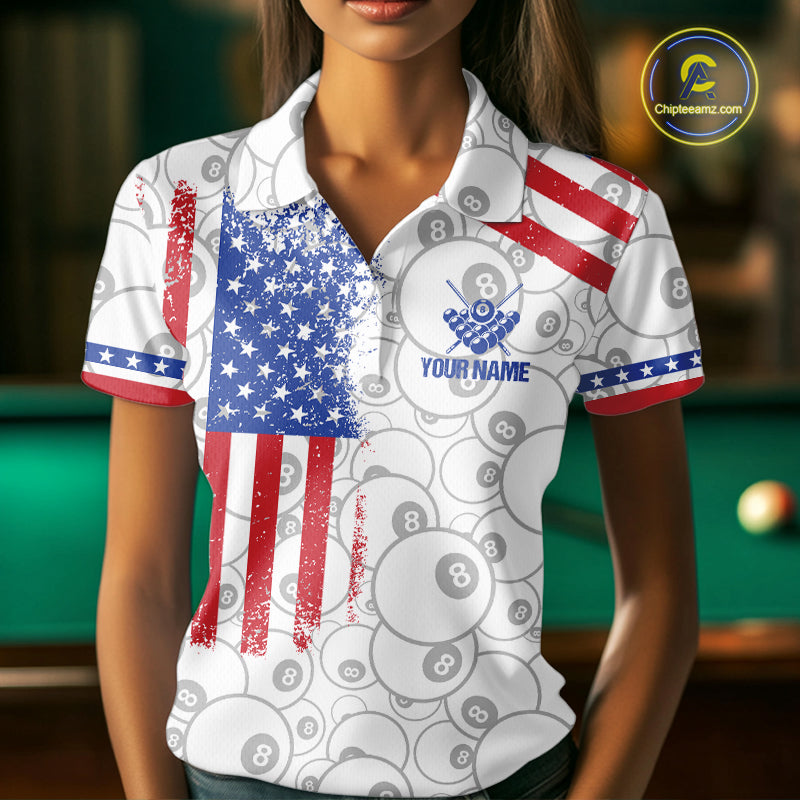Woman wearing a white American flag 8 ball billiard jersey beside a pool table front view.