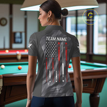 Load image into Gallery viewer, Back view of woman wearing a metal grey American flag 8 ball pool shirt in a billiards hall.