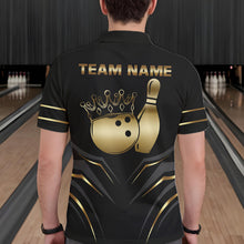 Load image into Gallery viewer, Back view of man wearing a black and gold crown bowling ball polo shirt inside a bowling alley.
