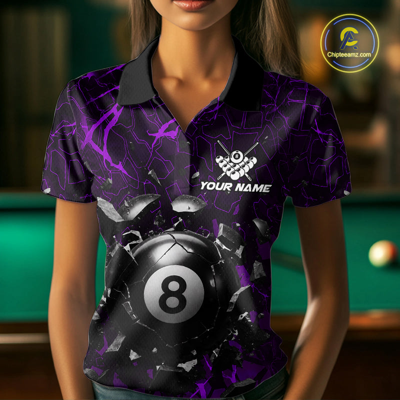 Woman wearing a purple crack 8 ball billiard jersey beside a pool table front view.