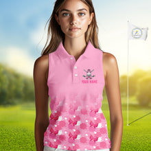 Load image into Gallery viewer, Woman wearing a pink sleeveless golf shirt with a floral pattern on a golf course.